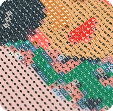 Macro of the printed symbol chart on canvas with square drills partially placed